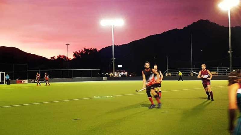 Competitive hockey players on field at night